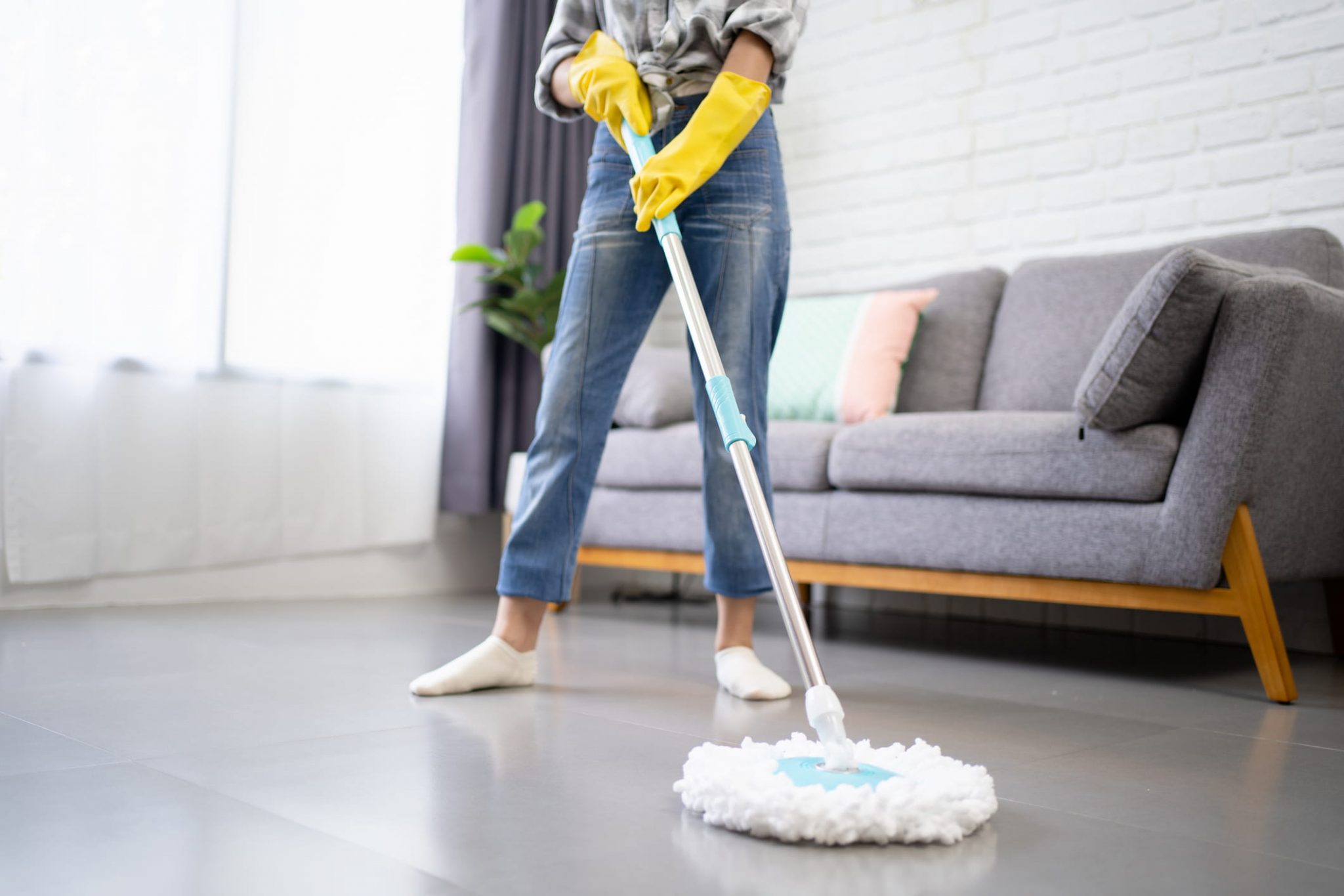 mulher usando esfregao para limpar piso frio