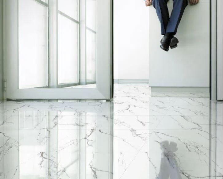 foto de piso acetinado com marmoreio em ambiente e pessoa sentada em bancada olhando