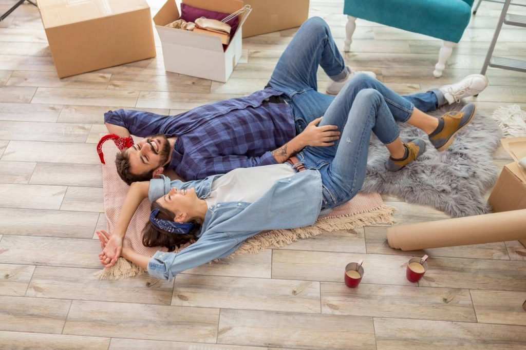 casal deitado confortavelmente no piso de sua casa