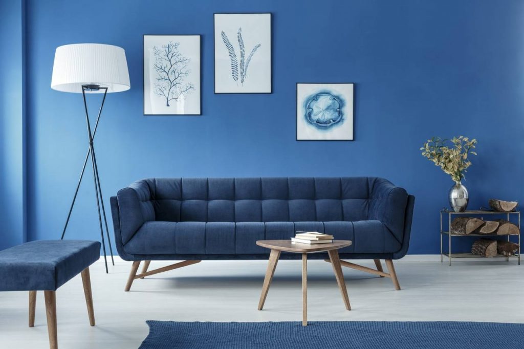 Parede da sala de estar pintada de azul combinando com o sofá