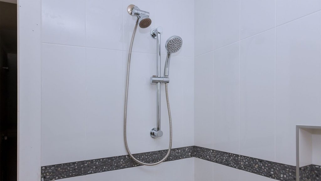 Entre as melhores duchas está a Ducha com desviador Tokyo 1 da marca Addra instalada em um banheiro
