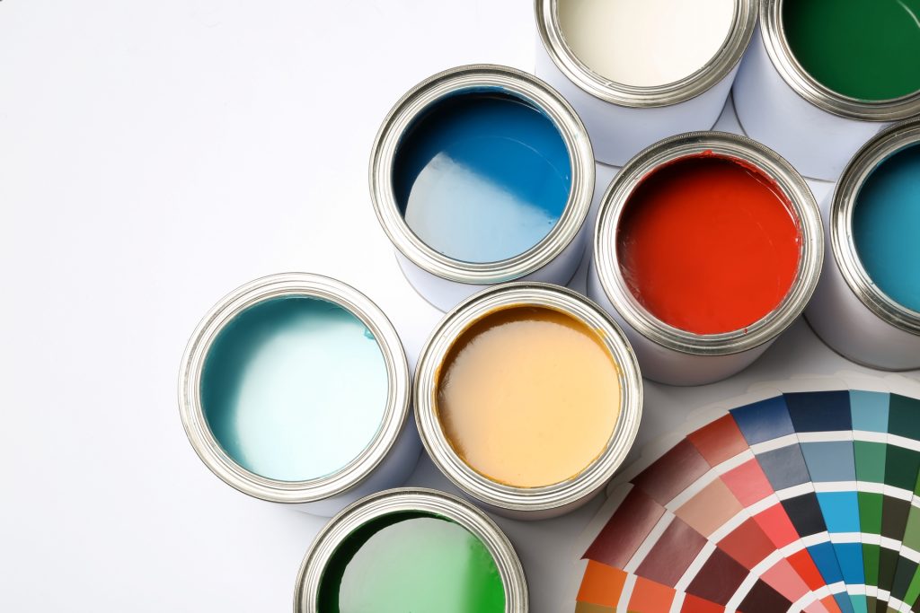 latas abertas de tintas para parede com diversas cores