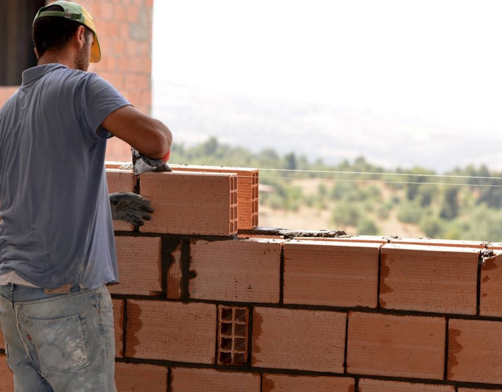 Homem construindo uma parede para uma casa nova