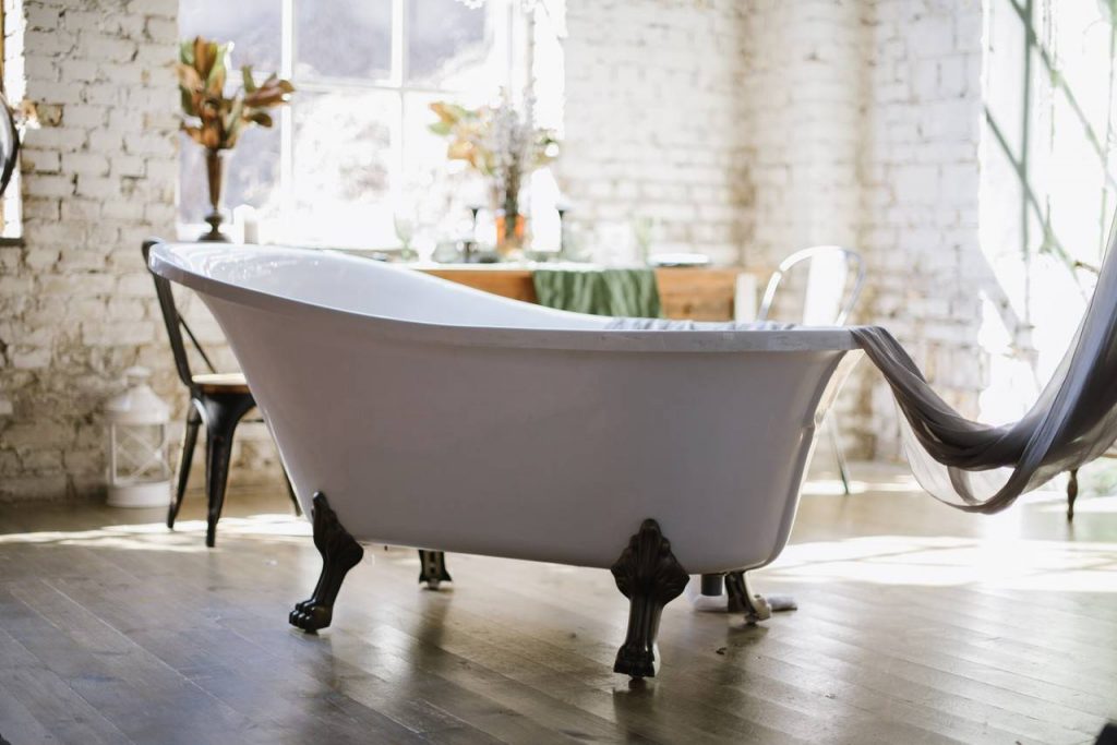 Imagem de uma banheira retrô em uma espécie de quarto formando um SPA em casa