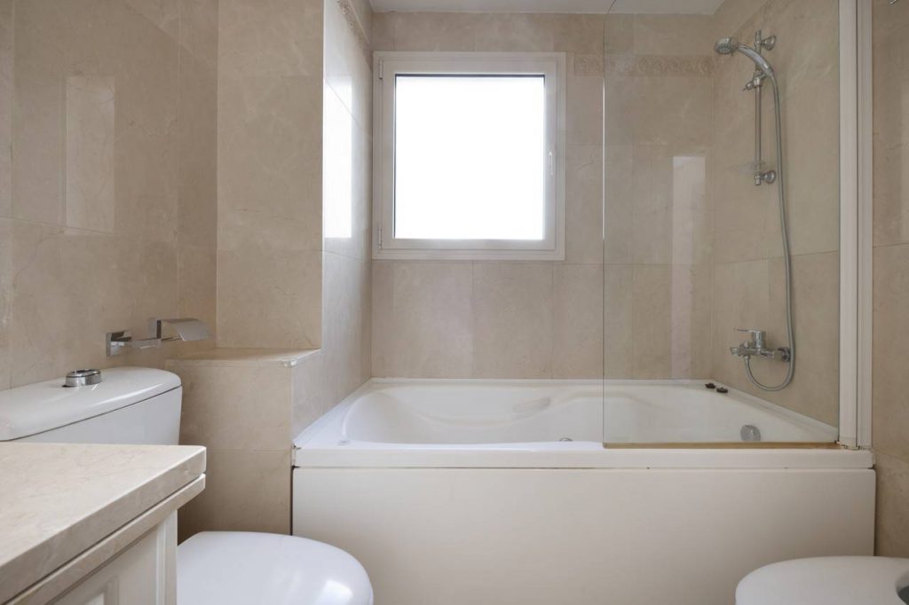 Banheiro com pisos escuros e uma banheira quadrada formando um SPA em casa