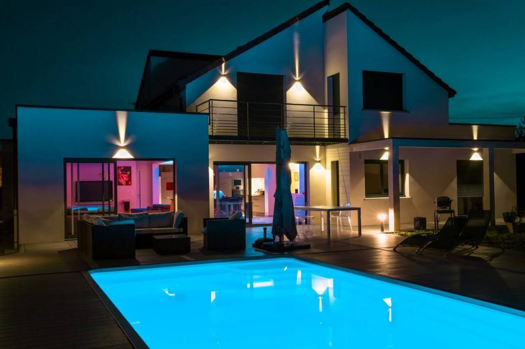 Imagem de uma casa com piscina e iluminação com led