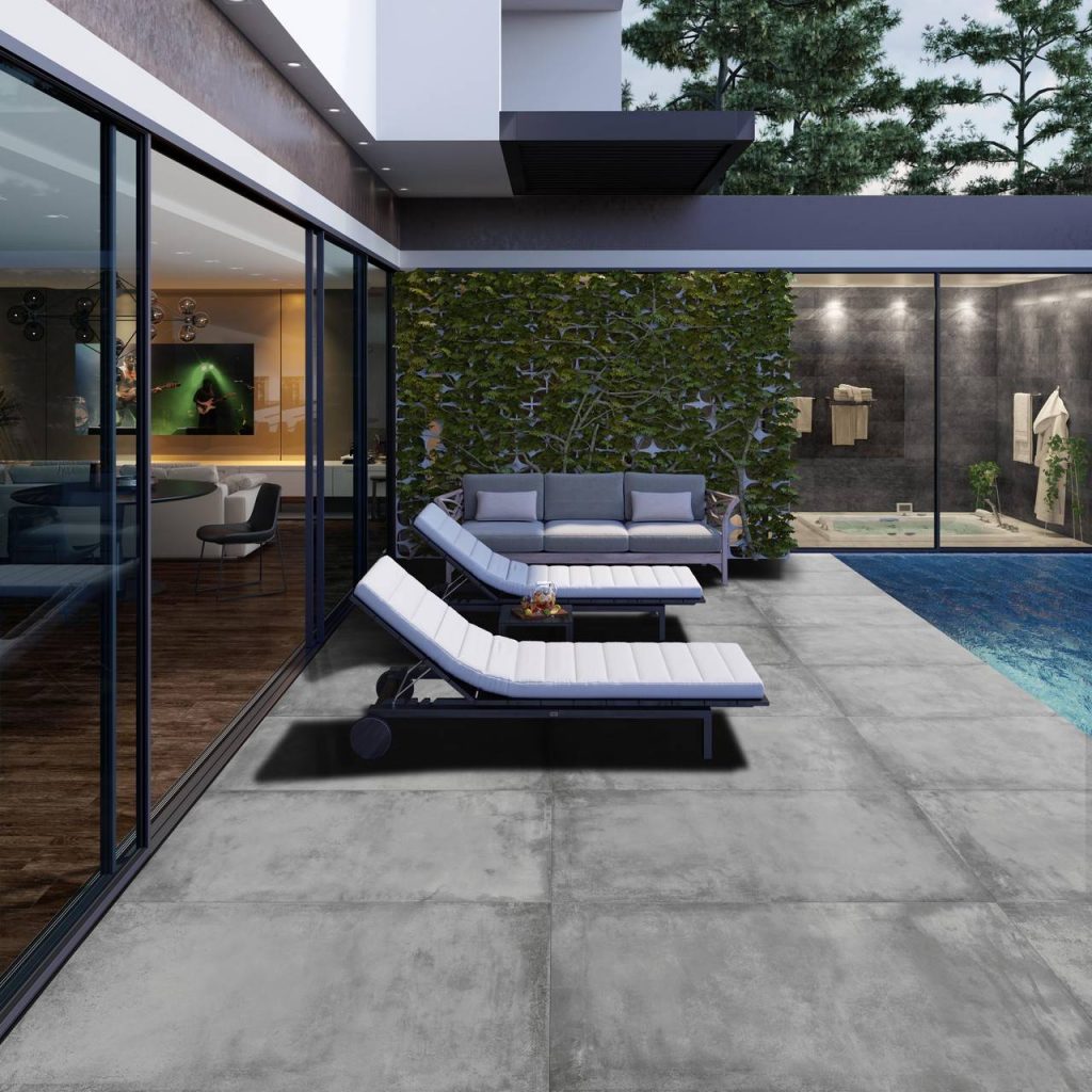 Imagem lateral de uma área externa decorada com poltronas confortáveis e uma piscina