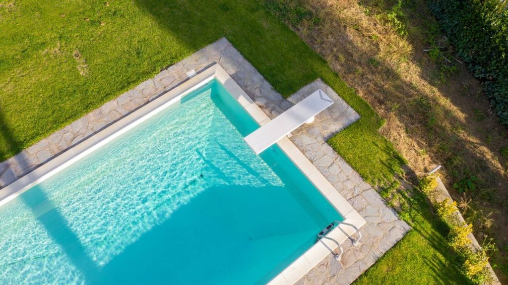 Imagem aérea de uma piscina com bordas de pedrais naturais