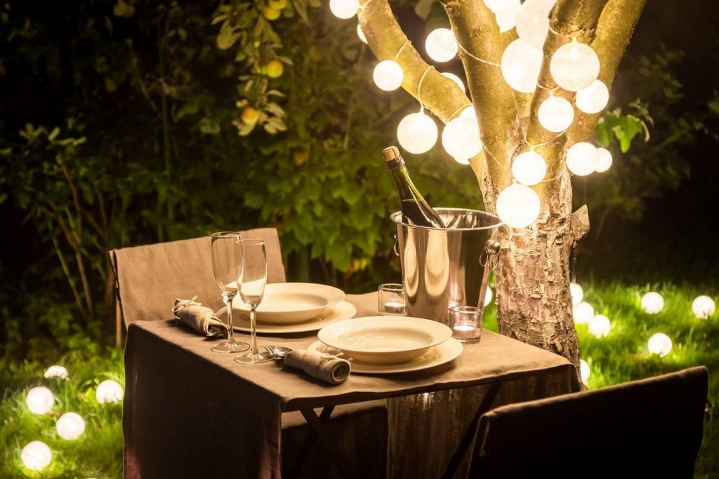 Mesa de jantar romântica em um ambiente externo com luzes brancas