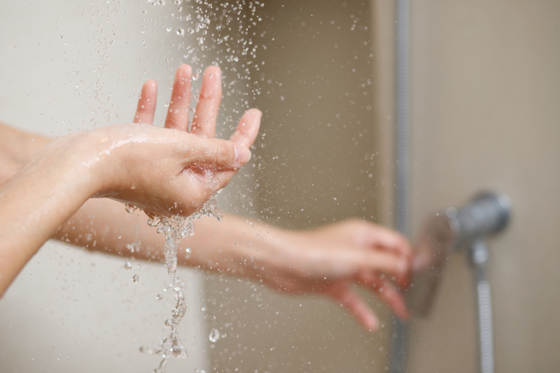 mulher abrindo o registro de água de um chuveiro para tomar banho