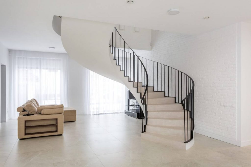 Escada circular feita de concreto com os corrimões em ferro é um dos tipos de escadas
