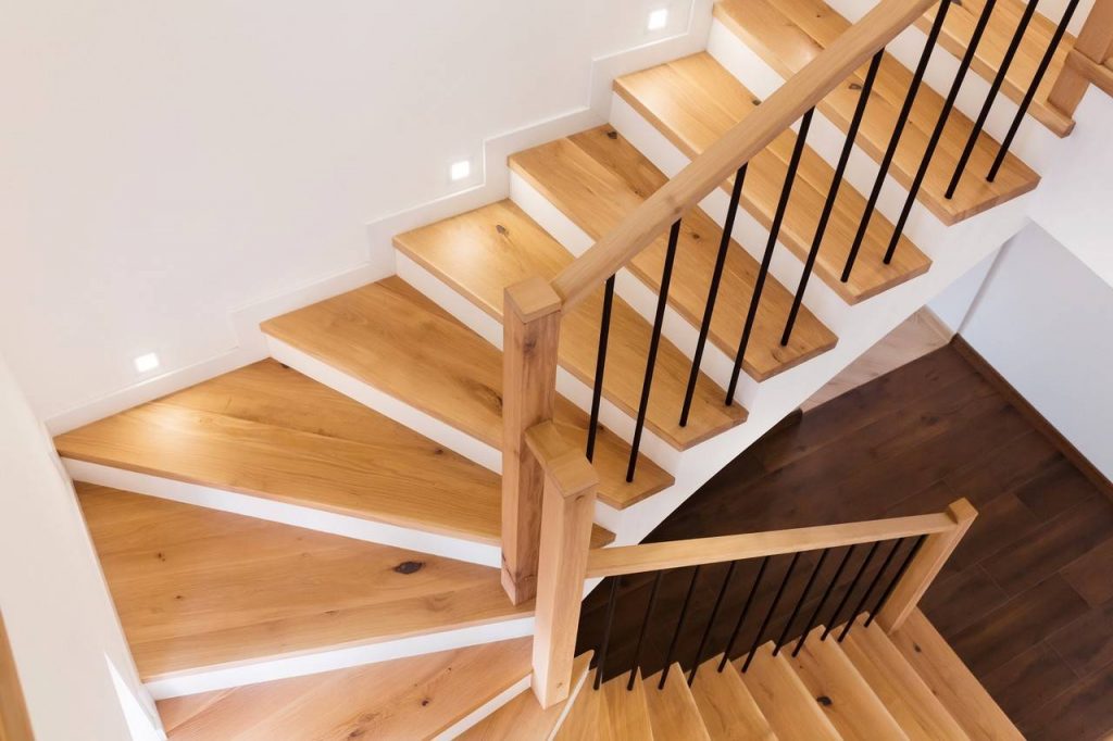 Escada em forma de leque feita de concreto e degraus em madeira é um dos tipos de escadas