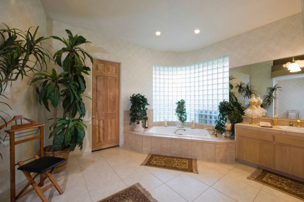 Banheiro com parede ampla feita de  tijolos de vidro