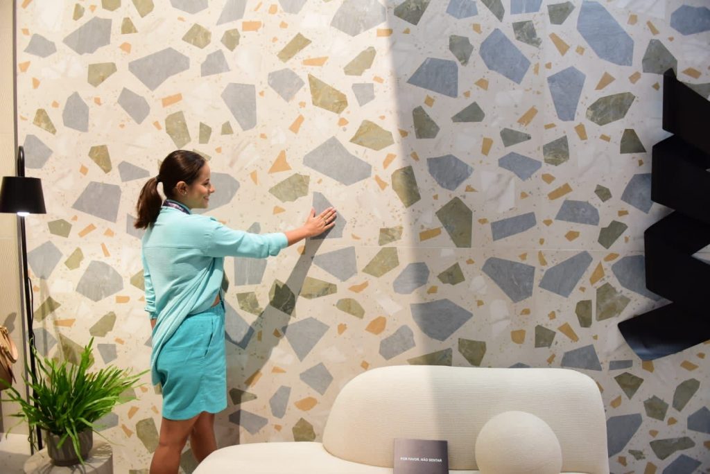 mulher analisando uma parede com revestimento cerâmico na expo revestir