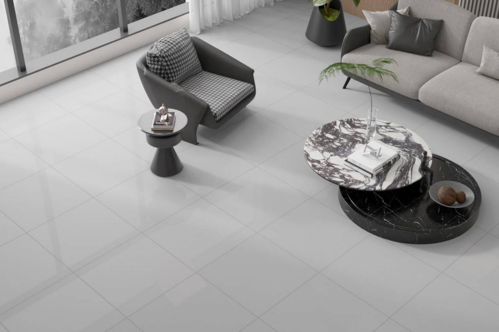 piso porcelanato aplicado em sala com poltrona cinza, mesa de centro, e sofá cinza ao lado