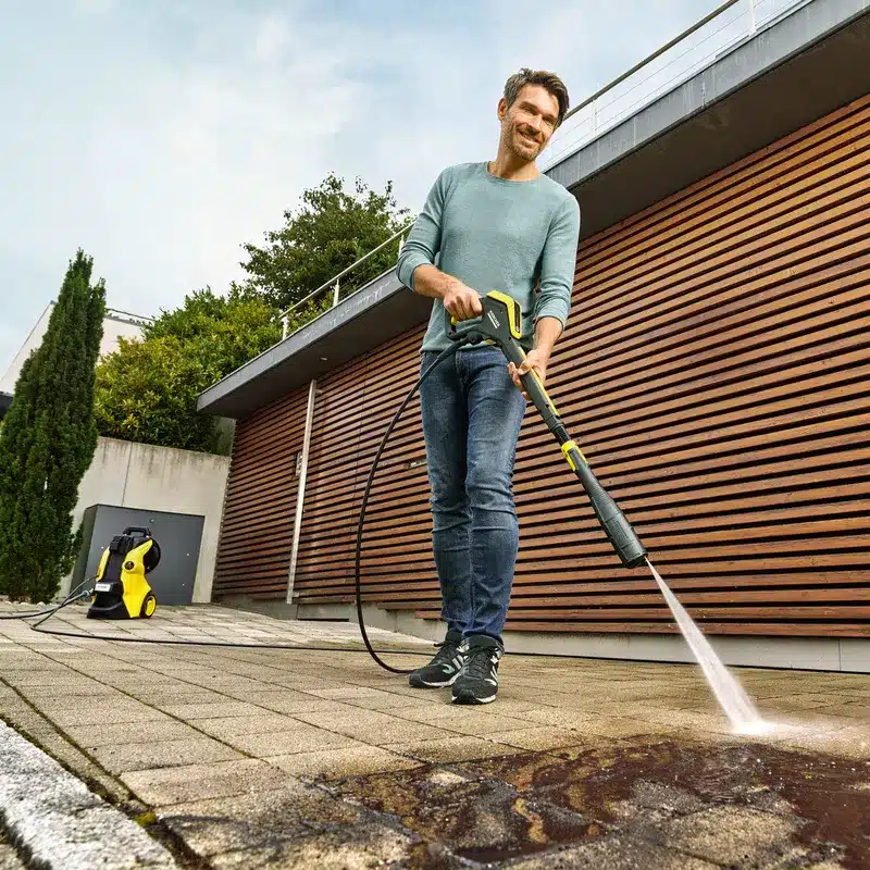 homem limpando a calçada com uma lavadora de alta pressão no dia do consumidor
