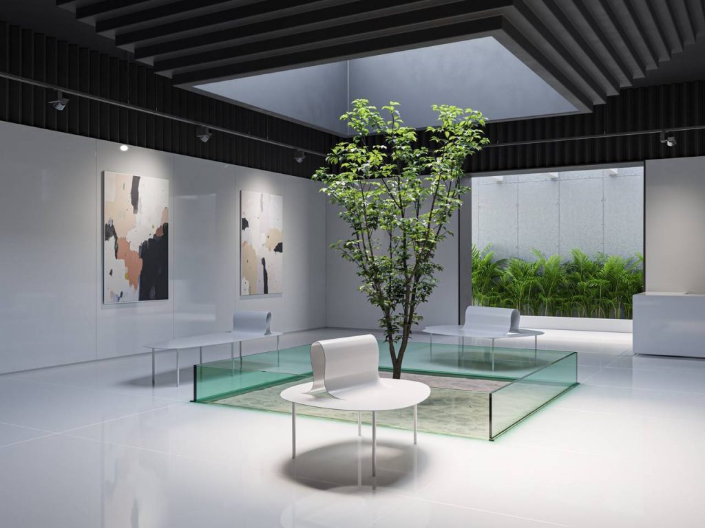 Sala de star com revestimento em porcelanato branco, mesas de canto arredondadas na cor branca, no centro árvore decorativa cercada com vidro esverdeado