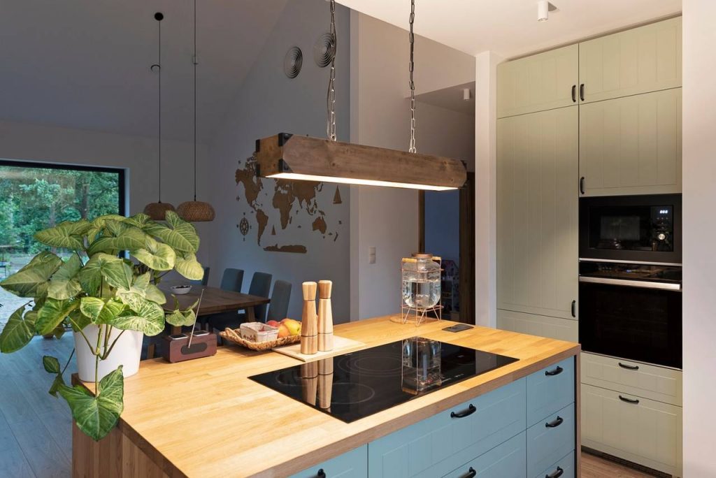 Cozinha decorada com móveis planejados, vasos de plantas, iluminação rebaixada são tendências para arquitetura