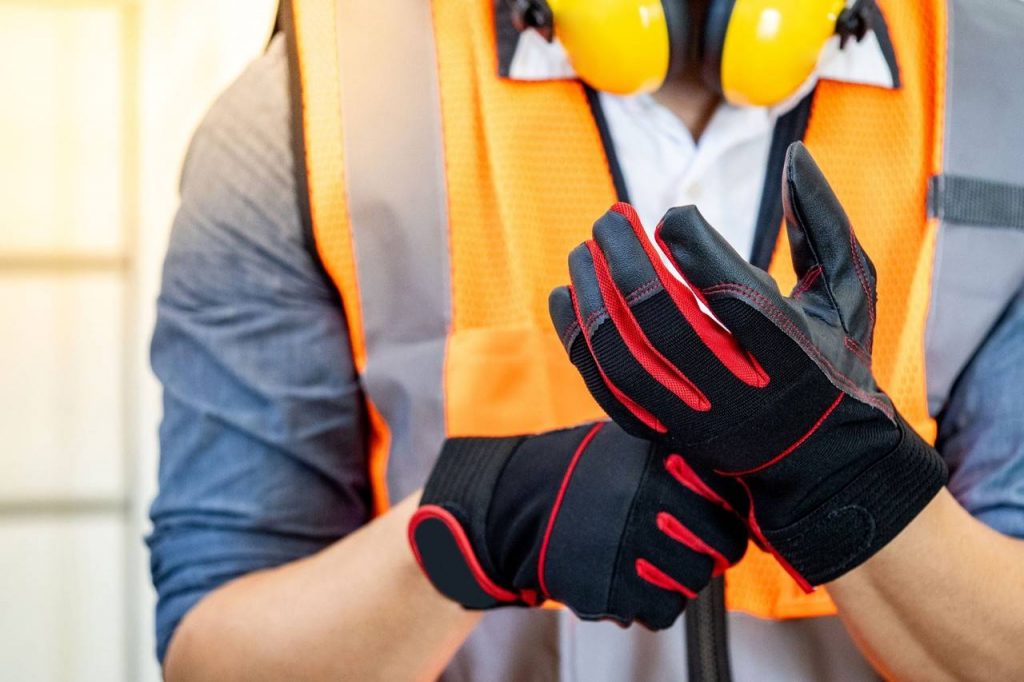 Trabalhados colocando luvas de proteção mostrando o que é epi