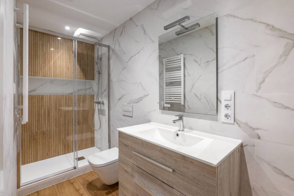 Banheiro com materiais de acabamento com paredes em estampa de mármore
