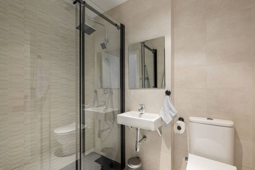 Banheiro estilo clássico com paredes no tom bege e detalhes preto e branco